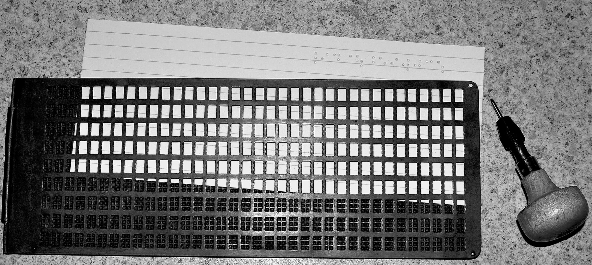 Eine Brailletafel mit Griffel