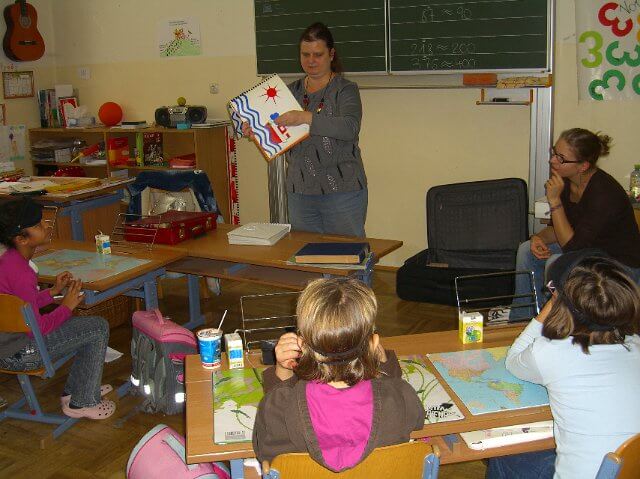 Sabine zeigt ein Buch vor der Klasse.