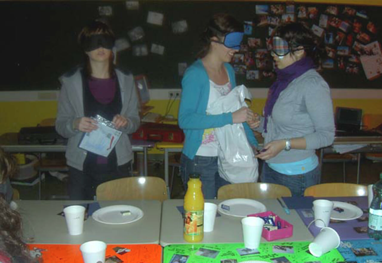 SchülerInnen der HLW Hollabrunn tragen Dunkelbrillen und decken den Tisch.